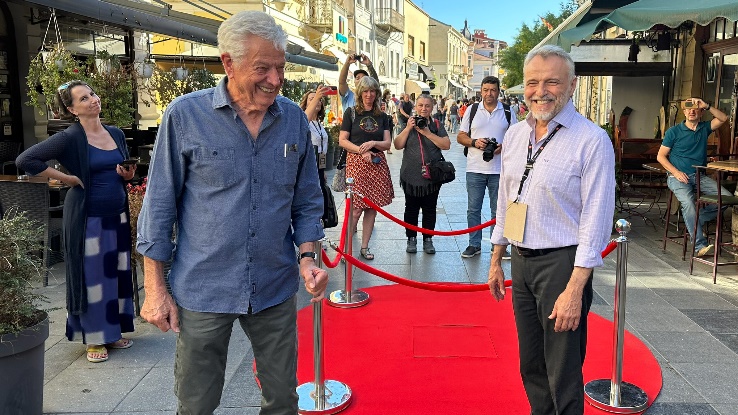 A group of men walking on a red carpet Description automatically generated